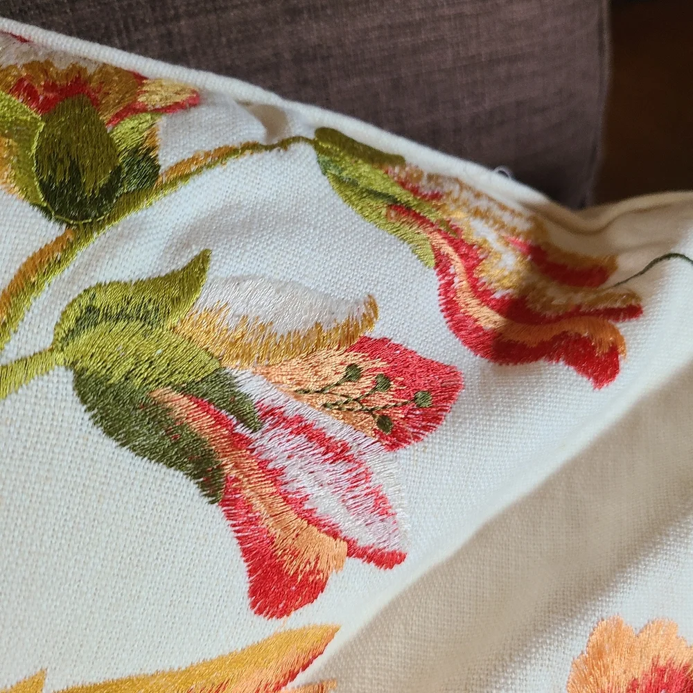 2 pillows with embroidered flowers and hummingbirds